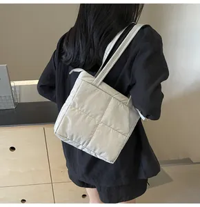 Dettaglio della borsa tote trapuntata crema con motivo a punto croce e zip