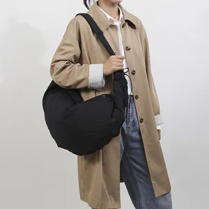 Minimalistische zwarte halve maan hobo tas met brede schouderband op een model
