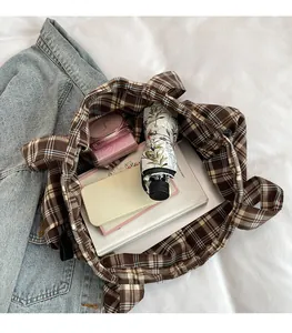 Detail shot showing the large interior capacity of the plaid tote bag with everyday items