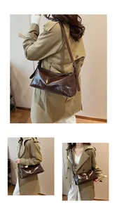 Détail du sac hobo marron foncé brillant avec rivets argentés et texture en cuir lisse