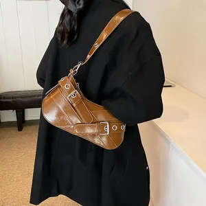 Glossy brown underarm saddle bag with silver buckles and punk style eyelet straps