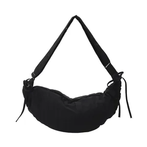 Minimalist black crescent crossbody bag with pleated nylon fabric and wide strap