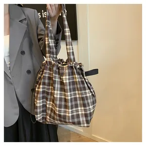 Detail of vintage plaid tote bag with drawstring closure and soft cotton fabric texture
