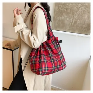 Detail of red plaid tote bag with drawstring closure and vintage tartan pattern texture