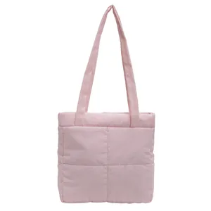 Detail of light pink quilted tote bag with soft padded texture and stitching finish