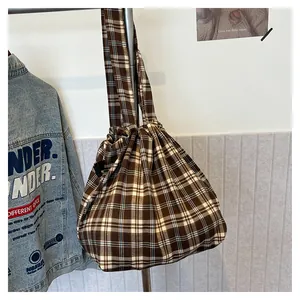 Detail of vintage checkered canvas tote bag with brown pattern hanging in life scene