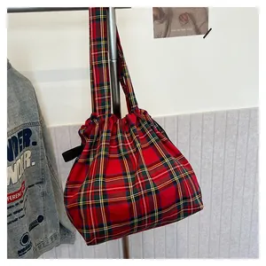 Detail of red tartan plaid tote bag with drawstring closure and durable canvas handles