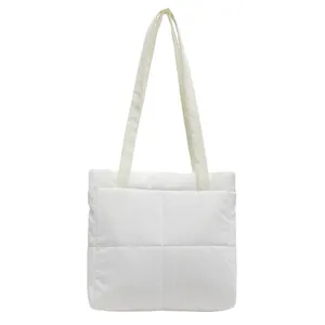 Detailed view of white quilted puffer tote bag with stitched grid pattern and soft straps