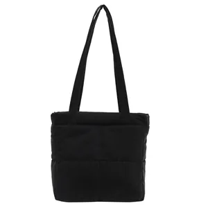 Detail shot of the black quilted texture and stitching on this padded nylon tote bag
