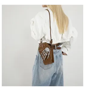 Close-up of coffin-shaped shoulder bag featuring silver skeleton hand and metal studs