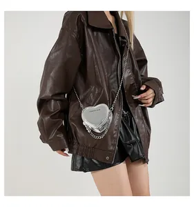 Detail of silver heart-shaped crossbody bag with metallic chain and mirror leather texture