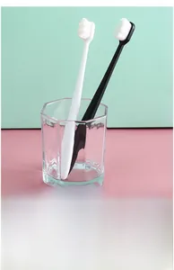 Detail showing 80-micron high-density soft bristles on black and white toothbrushes
