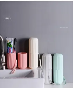 Vertical striped travel toothbrush case splitting into two cups on a marble sink surface