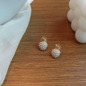 Macro shot of French vintage pineapple pearl earrings on a warm wooden background