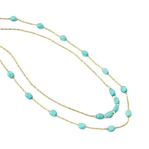 Minimalist double-layered gold chain necklace with faceted turquoise beads on white background