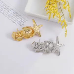 Detailed close-up of gold and silver sea star and shell hair clips for hair styling