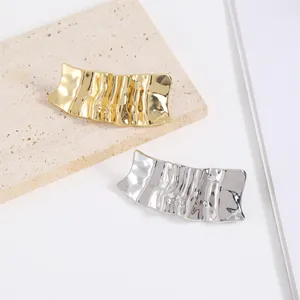 Irregular wavy metal hair clips set in gold and silver finish with textured surface