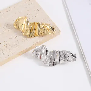 Macro detail of irregular gold and silver bow-shaped metal accessories on stone