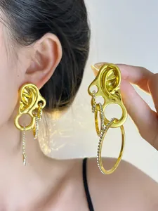 Detailed close-up of vintage gold ear-shaped earrings with rhinestones and rings
