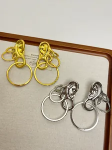 Detail of vintage-style ear-shaped earrings in gold and silver finish with rhinestones