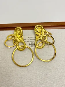 Detailed view of gold ear-shaped earrings with interlocking rings and micro-pavé crystals
