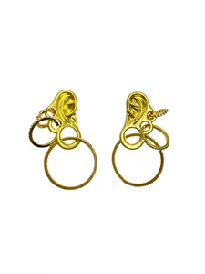 Macro detail of vintage gold ear-shaped stud earrings with sparkling crystal-encrusted rings