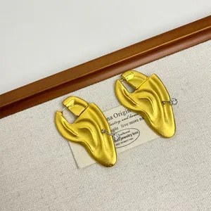 Macro detail of vintage gold textured earrings with sparkling small white crystals