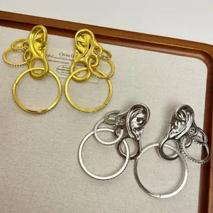 Vintage style gold and silver ear-shaped earrings with rhinestone interlocking rings