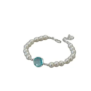 Elegant pearl bracelet with sky blue crystal centerpiece and silver metal lobster clasp closure