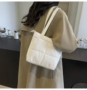 Detail shot of white quilted shoulder bag with grid stitching texture on trendy tote