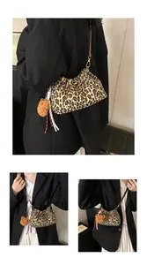 Detalle del bolso de leopardo con textura plisada y colgante de oso de peluche