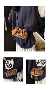 Detalle de bolso saco plisado de leopardo con colgante de oso de peluche y correa ajustable