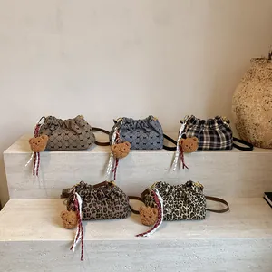 Set de mini bolsos tipo cubo de leopardo y cuadros con dijes de osito en escalones de piedra