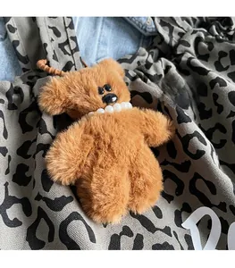 Detailed view of a plush brown bear charm with pearl necklace on a leopard tote bag