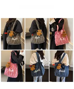 Detailed views of leopard print canvas tote bags with Beach embroidery and plush bear charms