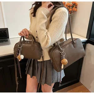 Detailed view of dark brown retro leather boston bags in two sizes with cute charms