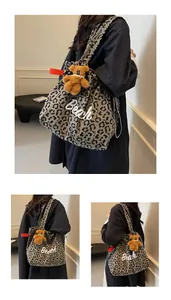 Detail of leopard print canvas tote bag with Beach lettering and plush bear charm accessory