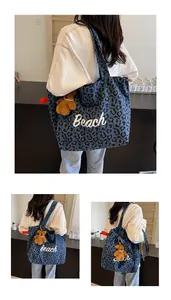 Detail of blue leopard print canvas tote bag with Beach embroidery and bear charm