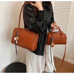 Detail of caramel brown PU leather bag set with silver zippers and shoulder straps