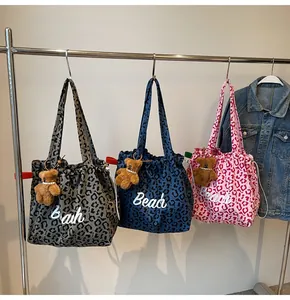 Three leopard print canvas tote bags with Beach text and plush bear charms hanging