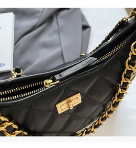 Détail du sac en cuir matelassé noir avec fermeture éclair dorée et fermoir rotatif