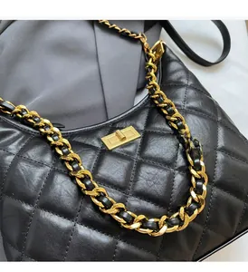Gros plan du sac en cuir noir matelassé avec chaîne dorée et fermoir pivotant