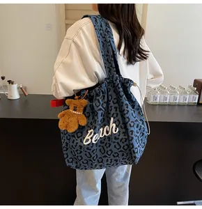 Blue leopard canvas tote bag featuring Beach text, plush bear charm and drawstring closure