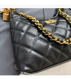 Détail de la texture cuir matelassé noir et chaîne en métal doré du sac à bandoulière