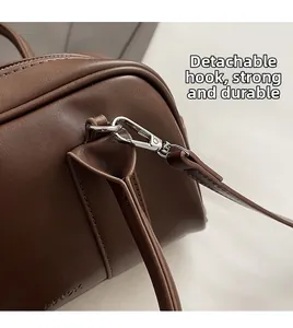 Close-up of durable silver metal hook and fine stitching on dark brown leather bag