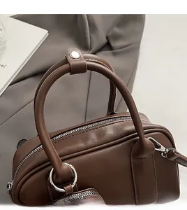Close-up of comfortable leather handle and durable silver hardware on brown handbag