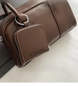 Detail of dark brown leather texture and square coin purse with embossed logo lettering