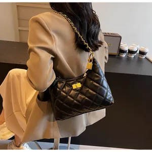 Détail du sac hobo matelassé noir avec fermoir doré et bandoulière en chaîne