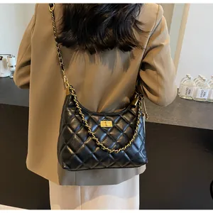 Détail du sac à bandoulière en cuir noir matelassé avec chaîne dorée et fermoir
