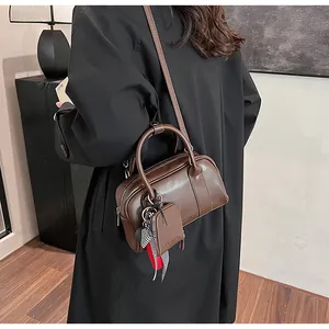 Detail of dark brown leather Boston bag with mini pouch and striped silk scarf accessory